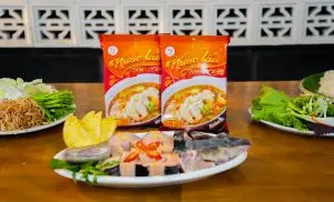 Nguyên liệu cá tầm tươi cùng gói nước lẩu chua cay và rau sống, chuẩn bị món lẩu cá tầm chua cay tại nhà